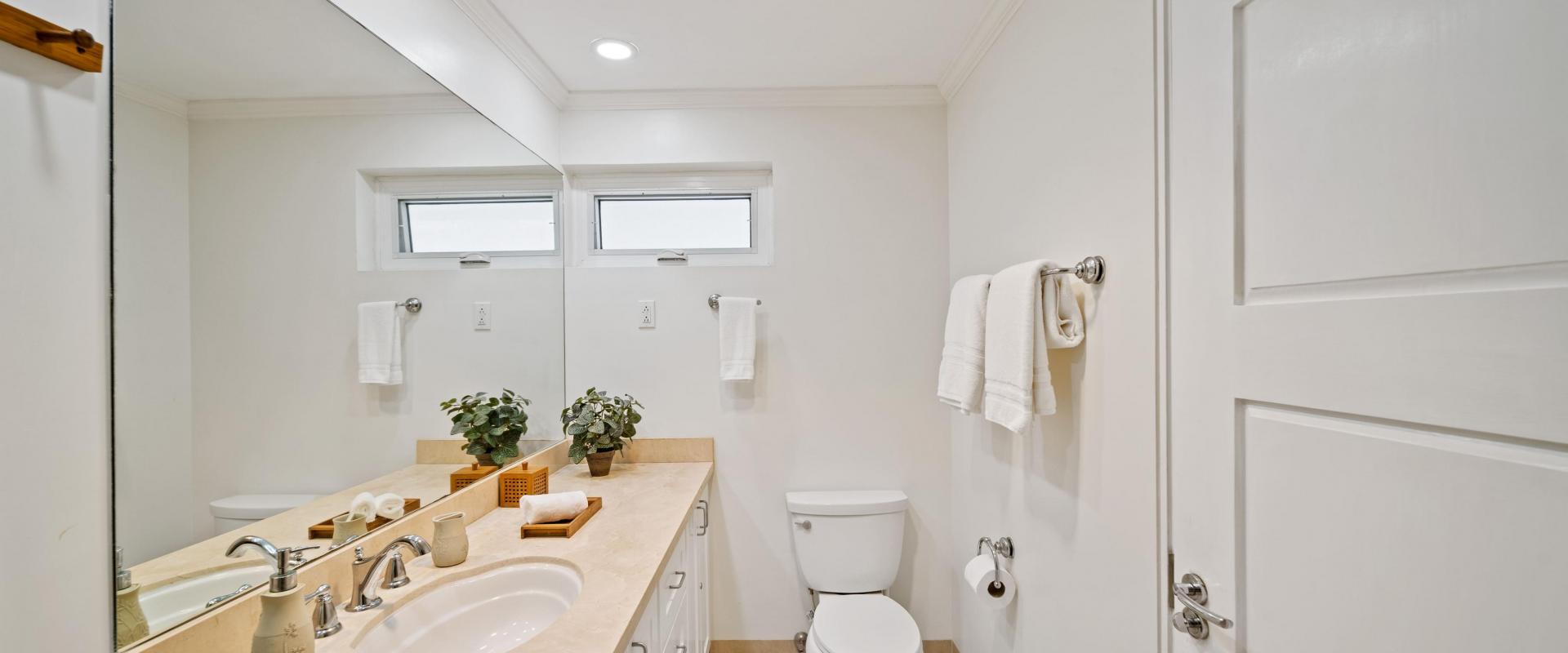 Palm Beach 102 Guest Bathroom – Holiday Condo in Barbados Guest bathroom at Palm Beach 102 Barbados featuring modern vanity, mirror and neutral tones