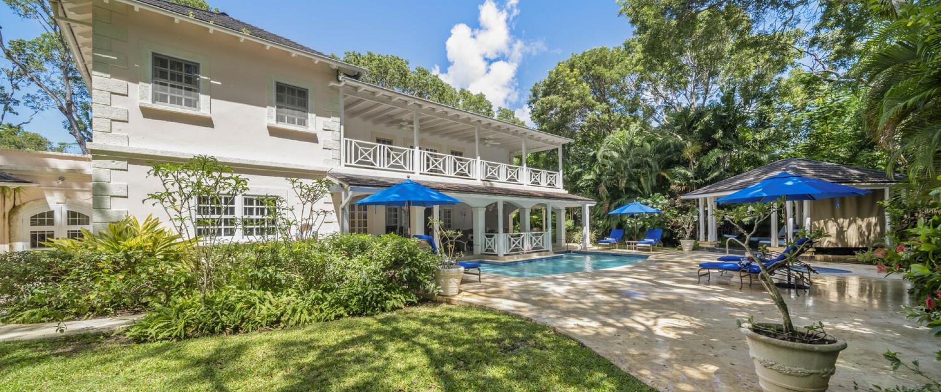 Exterior view of Sandalwood House, a luxury villa in Sandy Lane, Barbados, featuring a private pool and lush tropical gardens.