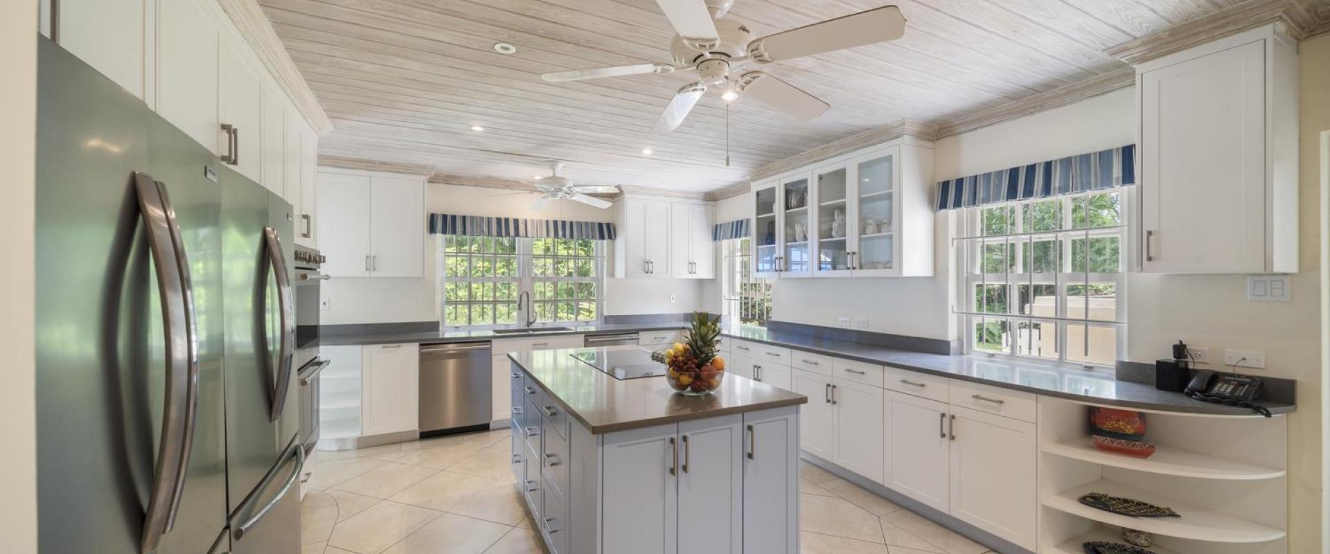 Spacious kitchen at Sandalwood House, featuring a large island, ample storage, and sleek stainless steel appliances.