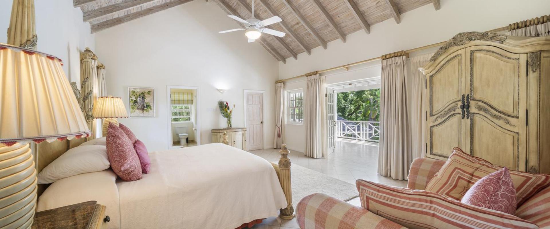 Elegant primary bedroom at Sandalwood House with high vaulted ceilings and access to a private terrace in Sandy Lane.