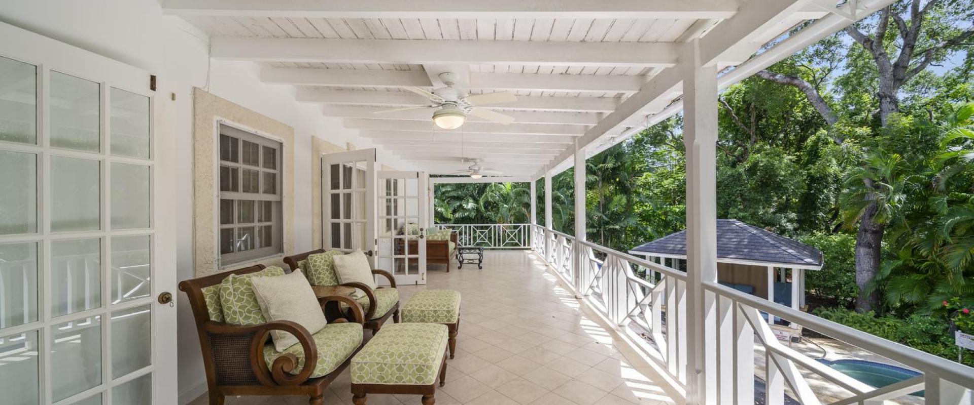 Expansive upper terrace at Sandalwood House with comfortable seating, offering views of the tropical gardens and pool.