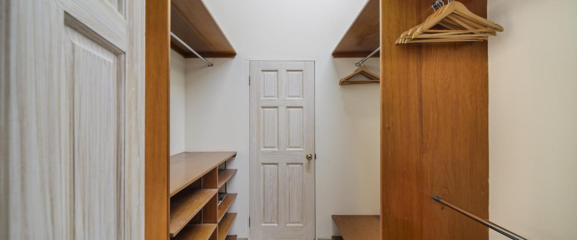 Walk-in closet at Sandalwood House, complete with ample storage space and shelving.