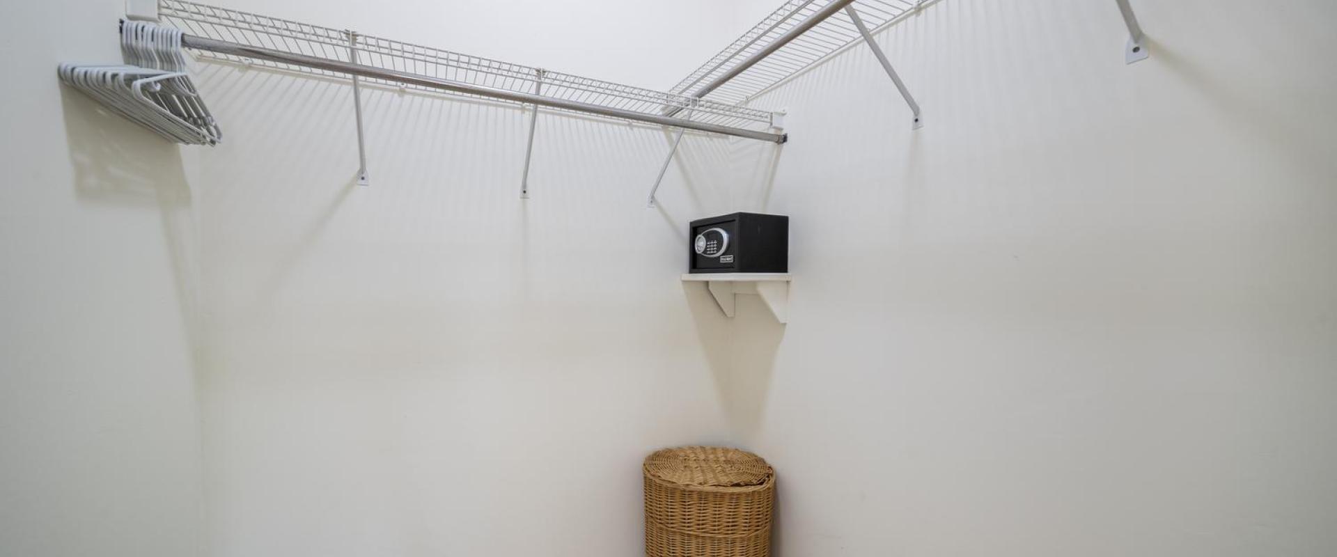 Spacious walk-in closet at Sandalwood House, complete with shelving and a personal safe.