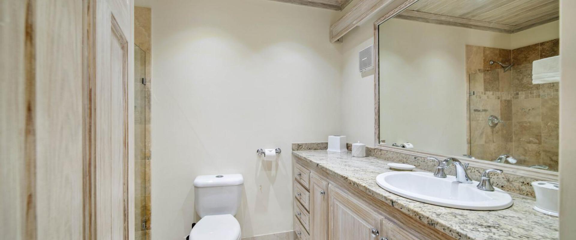 Contemporary bathroom in fourth bedroom at Sandalwood House, offering a stone-tiled shower, spacious vanity, and natural wooden finishes