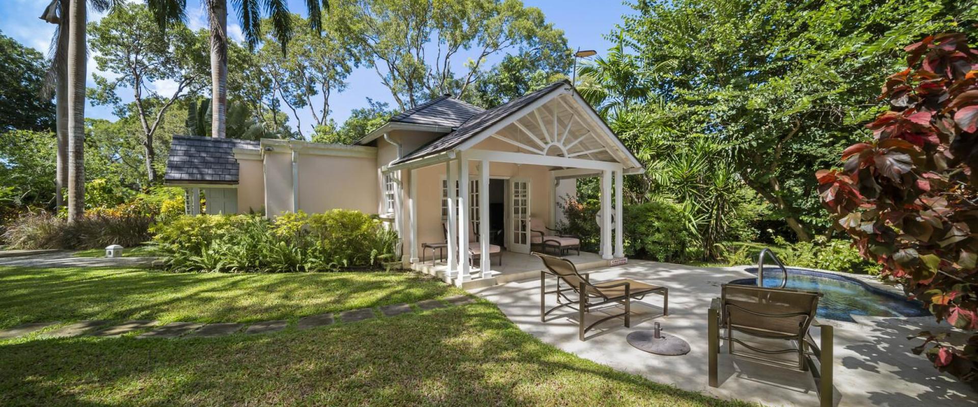 Secluded garden cottage patio at Sandalwood House, featuring lounge chairs, a small pool, and surrounded by lush tropical landscaping