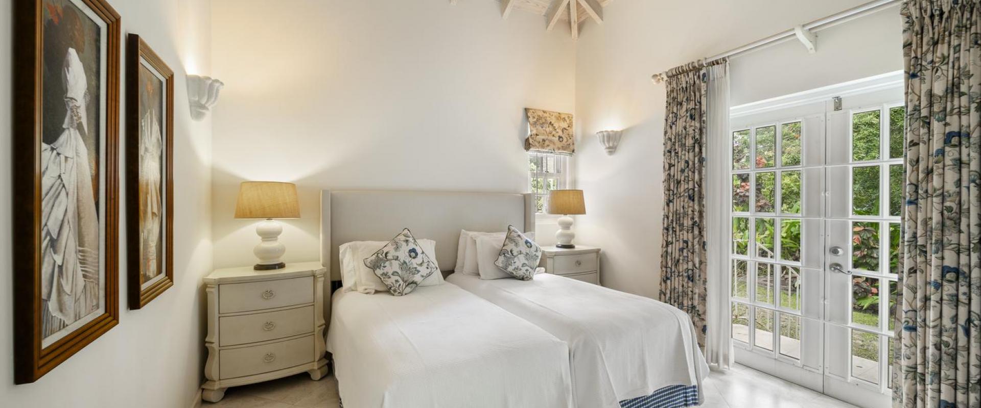 Bedroom Two of Cottage at Sandalwood House with high ceilings, light-filled windows, and direct access to the garden