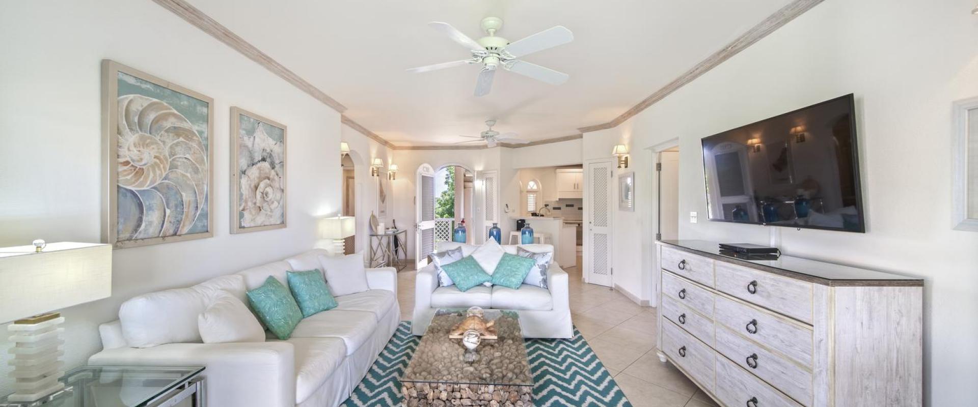 Coastal-themed living space in Seabreeze Penthouse, Sugar Hill Resort, Barbados, with white sofas, a unique driftwood coffee table, and turquoise accents, creating a relaxed yet refined environment ideal for unwinding.