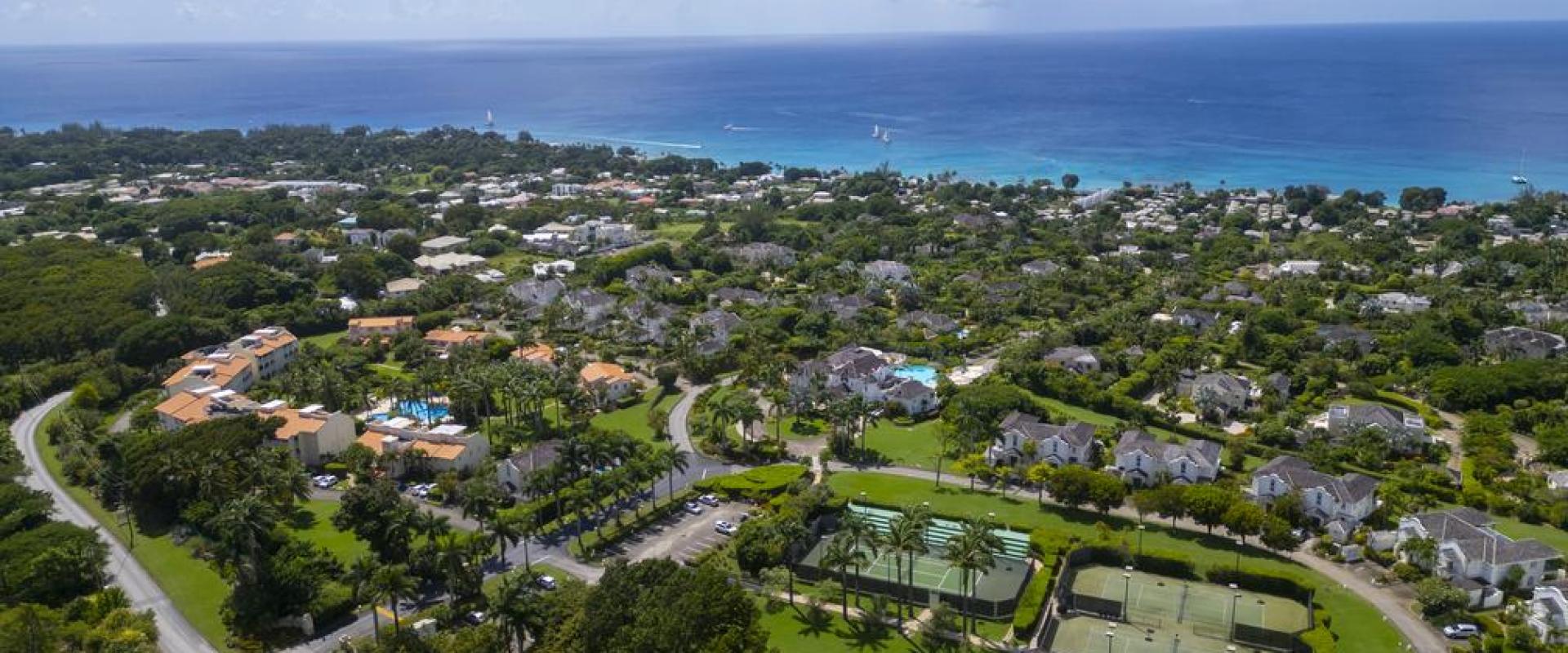 Another high-angle view over Sugar Hill Resort, showcasing the exclusive amenities including multiple tennis courts, expansive green spaces, and proximity to Barbados’ scenic coastline, ideal for a relaxing stay.