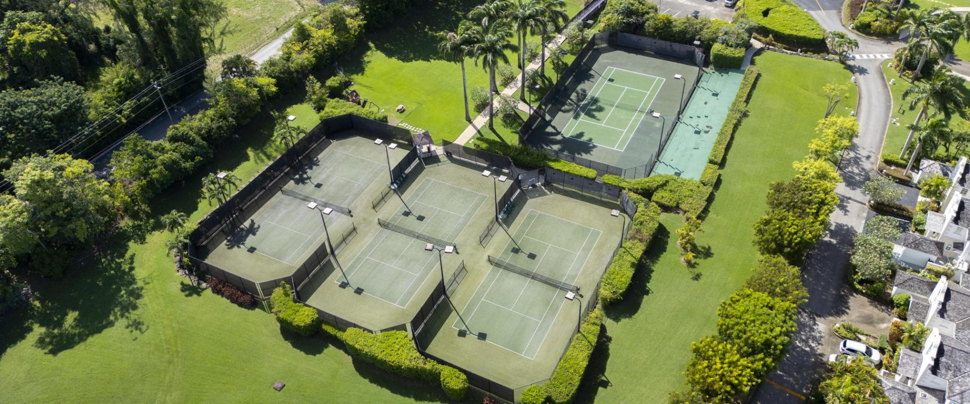 Sugar Hill Resort tennis courts in Barbados, surrounded by manicured lawns and tropical gardens, offering guests at Seabreeze Penthouse ample recreational facilities within the resort’s peaceful environment.