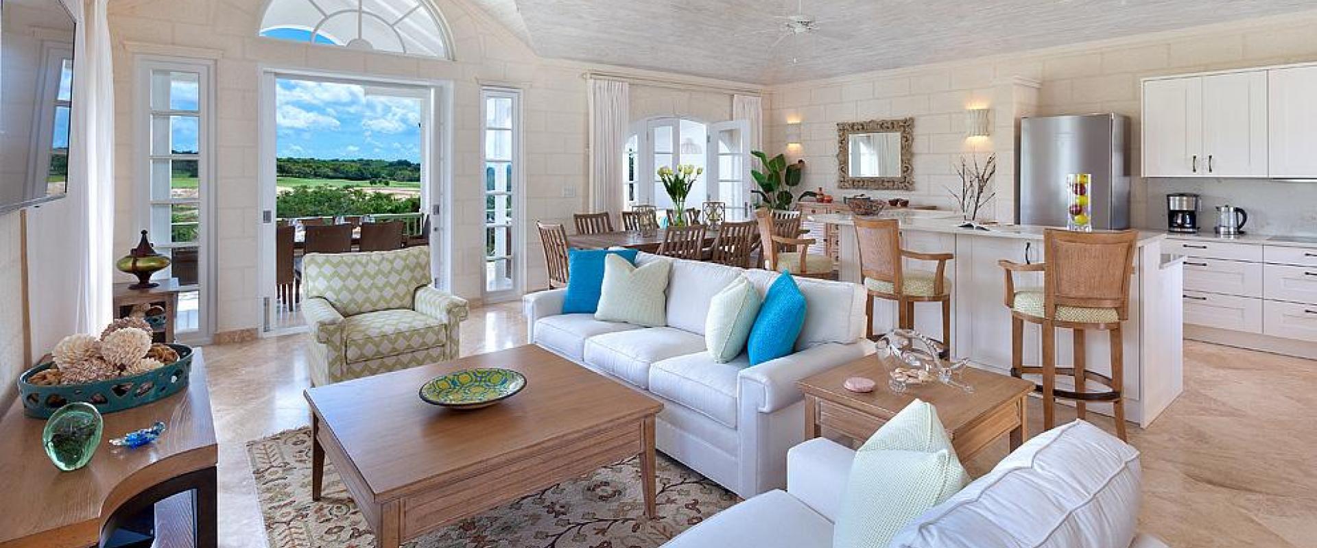Elegant open-plan living space with high ceilings, plush seating, and a modern kitchen at Sugar Cane Ridge 22, Royal Westmoreland.