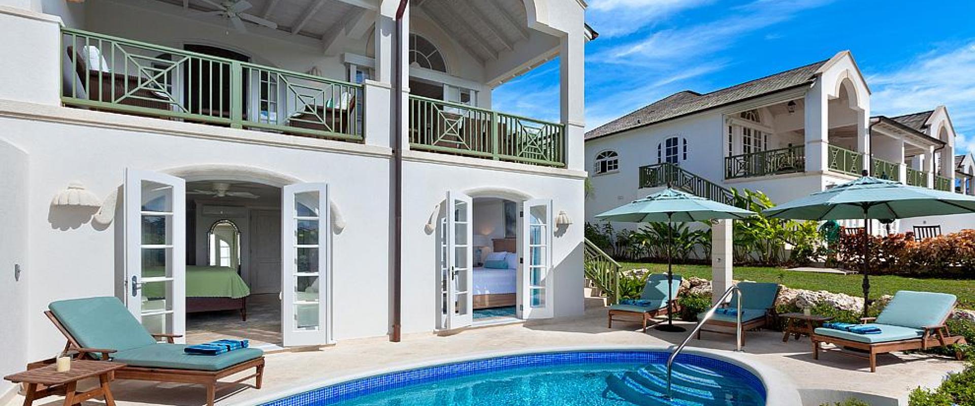 Stunning rear view of Sugar Cane Ridge 22, featuring a private pool, sun loungers, and a covered balcony overlooking the golf course.