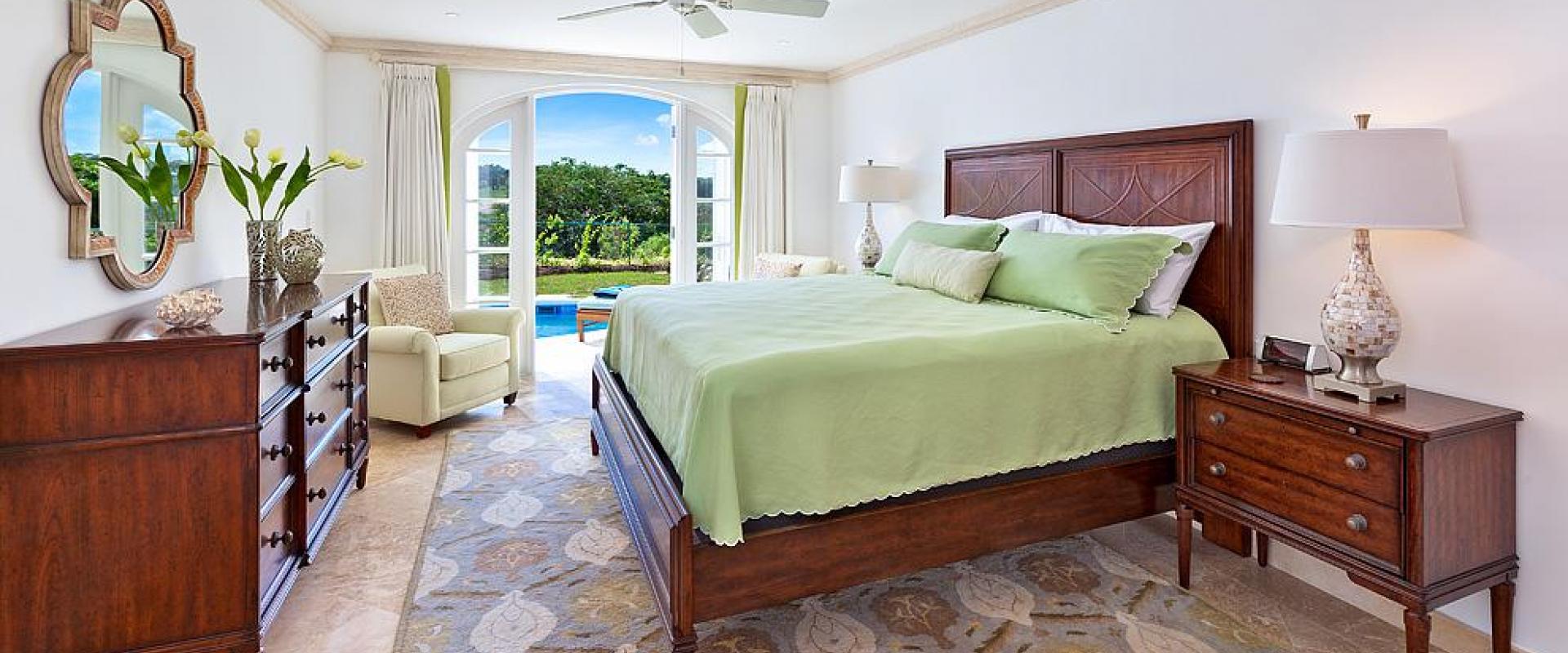Elegant second bedroom featuring a king-sized bed, garden views, and direct access to the private pool at Sugar Cane Ridge 22.