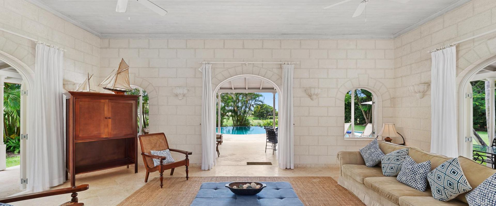 Spacious Caribbean-style living room with plush seating and views of the lush gardens at Villa Rosa, Barbados.