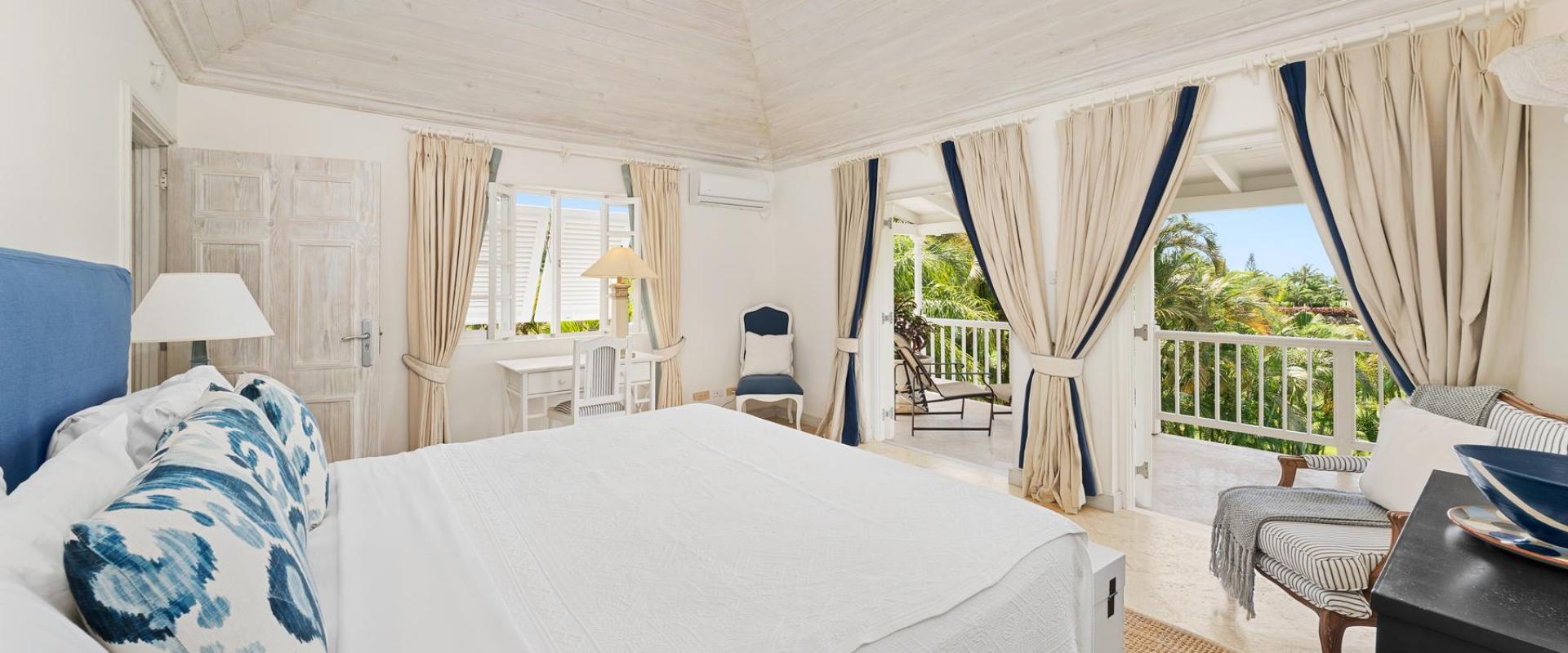 Luxury master bedroom at Villa Rosa with a four-poster bed, high ceilings, and access to a private balcony.