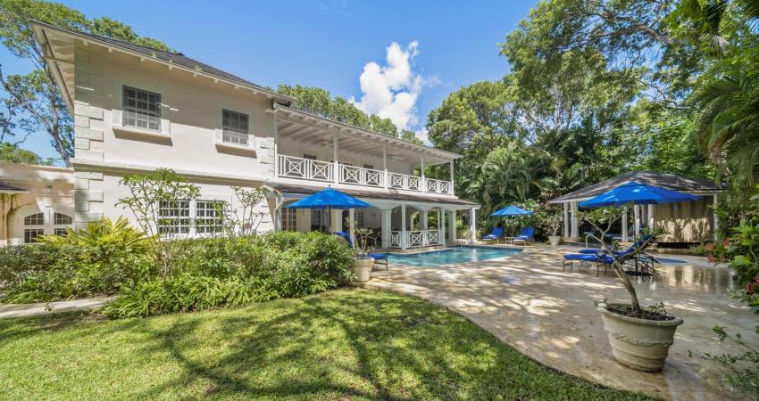 Exterior view of Sandalwood House, a luxury villa in Sandy Lane, Barbados, featuring a private pool and lush tropical gardens.