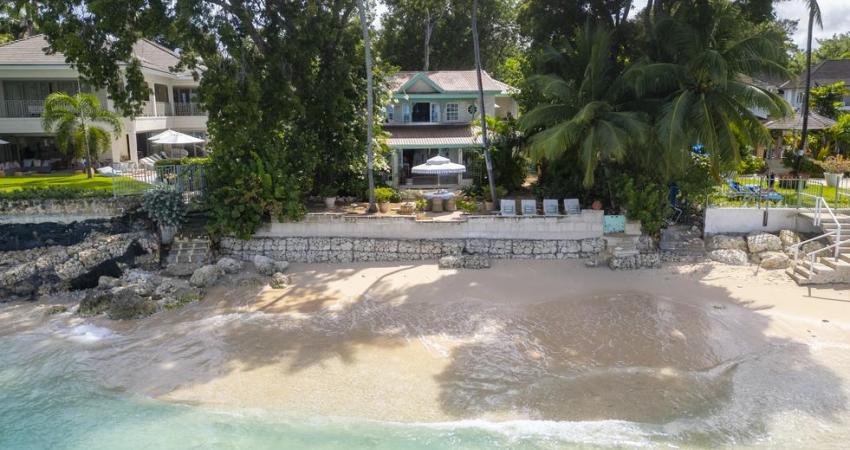 A luxurious beachfront villa in Barbados, Seascape boasts direct access to a pristine private beach, surrounded by tropical gardens and offering stunning views of the Caribbean Sea, perfect for a tranquil holiday rental.