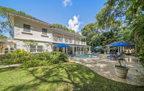 Exterior view of Sandalwood House, a luxury villa in Sandy Lane, Barbados, featuring a private pool and lush tropical gardens.